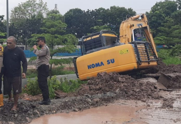 Inilah belko (alat berat) yang tengah membuat parit untuk mengurangi dampaok debit air yang tidak tertampung lagi akibat hujan Jumat (7/10/2022). (f: muhammad amin - batamtv.com)