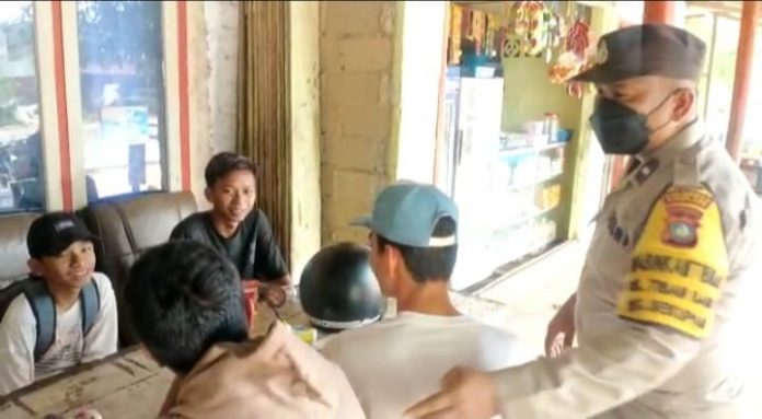 Untuk  mengantisipasinya, anggota  Bhabinkamtibmas Tiban Baru Polsek Sekupang Aipda Indo, (kanan) mengingatkan  ke siswa di  SMA 24  Sekupang yang kebetulan didapatinya sedang nongkrong-nongkrong setelah pulang sekolah, Selasa (18/10) . (Foto : muhammad amin - batamtv.com)