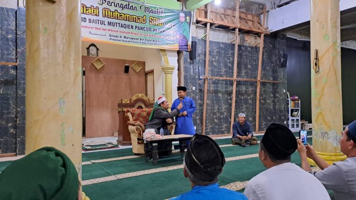 Ustadz Marsapwan bin Abdul Wahab saat berdialog dengan salah satu remaja masjid dalam Peringatan Maulid Nabi Muhammad SAW, Senin (24/10/2022) (Foto : muhammad amin - batamtv.com)