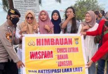 read news- Waspadai Cuaca Buruk saat Berwisata di Pantai di Batam Anggota Polsek Sekupang, Briptu Zemil (kiri) memberikan himbauan untuk berhati hati saat berwisata di pantai Tanjungpinggir, Minggu (23/10/2022). (Foto : muhammad amin - batamtv.com)