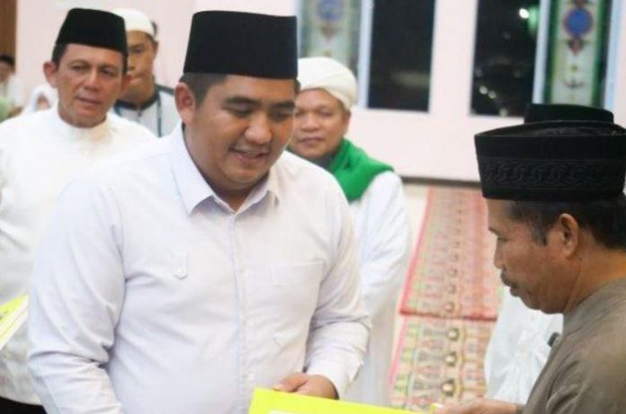 Bupati Bintan, Roby Kurniawan saat menyerahkan bantuan secara simbolis wifi gratis bagi rumah ibadah di Kabupaten Bintan Minggu (9/10/2022) malam. (Foto : dwi susilo-batamtv.com)