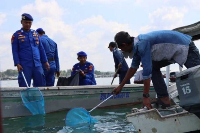 Bersama para nelayan, jajaran Satpolairu Polresta Tanjungpinang melakukan bersih laut, Jumat (21/10/2022) di laut. (Foto : dwi susilo - batamtv.com,)