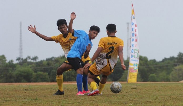 Seorang pemain penyerang asal Batam (kaus biru) dihadang oleh dua pemain dari Bintan di babak penyuisihan grup Rabu (9/11/2022) (Foto dwi susilo - batamtv.com)