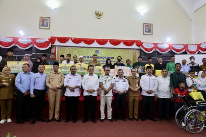 Gubernur Kepri Ansar Ahmad (nomor enam dari kiri) menyerahkan bantuan mubaligh tahap kedua bagi Kecamatan Karimun, Meral Barat, Meral dan Tebing, Selasa (06/12). Penyerahan dilakukan di Karimun Besar, tepatnya ke Gedung Nasional. Dalam acara tersebut disejalankan penyerahan secara resmi Lahan Bandara Raja Haji Abdullah Karimun dengan luas lahan yang dinilai sebesar 41,133 m2. Adapun nilai ganti kerugian mencapai Rp 4,9 miliar. Bantuan berasal dari anggaran Biro Kesra tahun 2022 dengan total anggaran Rp 8 miliar. (Foto : Dwi Susilo - batamtv.com) Gubernur Kepri Ansar Ahmad (nomor enam dari kiri) menyerahkan bantuan mubaligh tahap kedua bagi Kecamatan Karimun, Meral Barat, Meral dan Tebing, Selasa (06/12). Penyerahan dilakukan di Karimun Besar, tepatnya ke Gedung Nasional. Dalam acara tersebut disejalankan penyerahan secara resmi Lahan Bandara Raja Haji Abdullah Karimun dengan luas lahan yang dinilai sebesar 41,133 m2. Adapun nilai ganti kerugian mencapai Rp 4,9 miliar. Bantuan berasal dari anggaran Biro Kesra tahun 2022 dengan total anggaran Rp 8 miliar. (Foto : Dwi Susilo - batamtv.com)