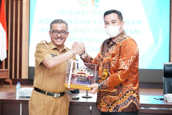 Bupati Pesawaran Provinsi Lampung Dendi Ramadhona (kanan) menyerahkan cenderamata khas Propinsi Lampung kepada Sekretaris Daerah (Sekda) Kota Batam Jefridin Hamid mewakili Wali Kota Batam Muhammad Rudi.  Dalam acara yang berlangsung  di Ruang Embung Fatimah kantor Wali Kota Batam, Senin (19/12/2022).  Dendi mengatakan kunker dimaksudkan ingin mencontoh Kota Batam dalam hal pengelolaan pendapatan asli daerah (PAD).  (Foto : Muhammad Amin - batamtv.com)