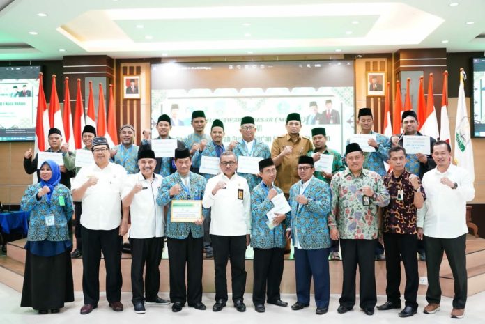 Sekretaris Daerah (Sekda) Kota Batam, Jefridin Hamid (tengah baju putih) saat hadir dalam musyawarah besar (Mubes) ke-VI Badan Musyawarah Guru Alquran (BMGQ) Kota Batan, Selasa (20/12/2022). Jefridin mengatakan kepada Pengurus baru BMGQ diharapkan nantinya dapat menyusun program-program dan menjalankannya dengan baik sebagaimana yang diharapkan. (Foto : Muhammad Amin - batamtv.com)