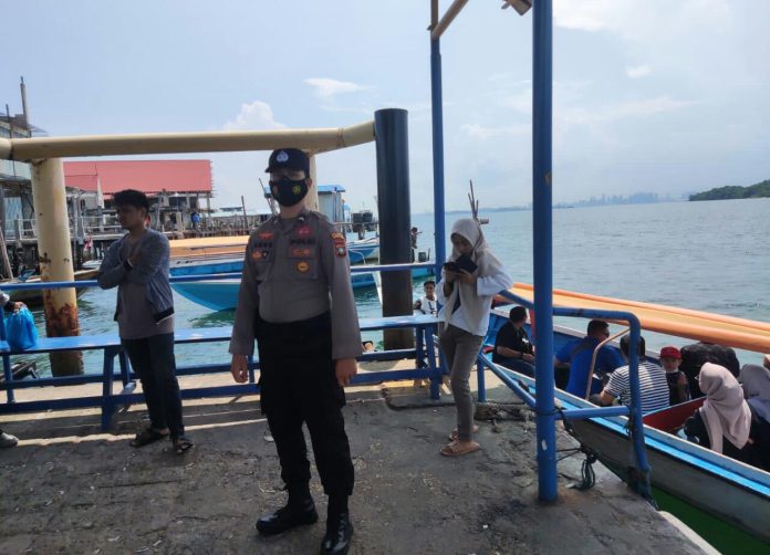 Anggota Polsek Belakang Padang , Bharada Anas saat memberikan teguran dan sosialisasi soal pentingnya menjaga dan tidak membuang sampah di laut di Belakang Padang. Sosialisasi ini dilaksanakan di Pelabuhan Rakyat Selasa (6/12/2022). Penegasan ini disampaikan mengingat kebersihan laut di Belakang Padang mulai harus digerakkan kembali untuk menjaga kelestarian lingkungan laut. (Foto : Muhammad Amin - batamtv.com)