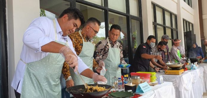 Peringatan Hari Ibu ke-94 dan HUT Dharma Wanita Persatuan ke-23  di Aula Kantor Bupati Bintan, Kamis (22/12) siang diramaikan lomba meamasak. Bupati Bintan Roby Kurniawan (kiri)  dan timnya yakni Kepala BPMPKB Aupa Samake. dan Kepala Dispora Bintan Hasfi Handra memasak mie goreng tekejut melawan Jendaras Karloan, Yusfreyendi dan Sumartono, tim dari insan pers dengan tema masakan mie goreng laki bersama. (Foto : Dwi Susilo - batamtv.com)