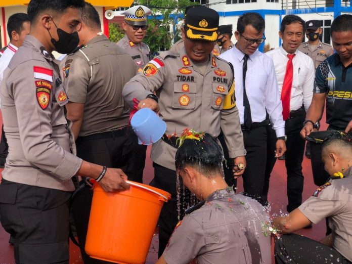 Kapolres Bintan, AKBP Tidar Wulung Dahono lakukan siraman pada Prosesi upacara kenaikan pangkar Polres Bintan dilakukan di halaman Polres Bintan, Senin (2/1/2023). Beberapa nama perwira yang naik pangkat yaitu AKP menjadi Kompol, Iptu menjadi AKP. Serta Ipda menjadi Iptu, Bripka menjadi Aipda, kemudian Brigpol menjadi Bripka. Terkahir, personel berpangkat Briptu menjadi Brigpol, dan Bripda menjadi Briptu. ( foto : dwi susilo - batamtv.com)