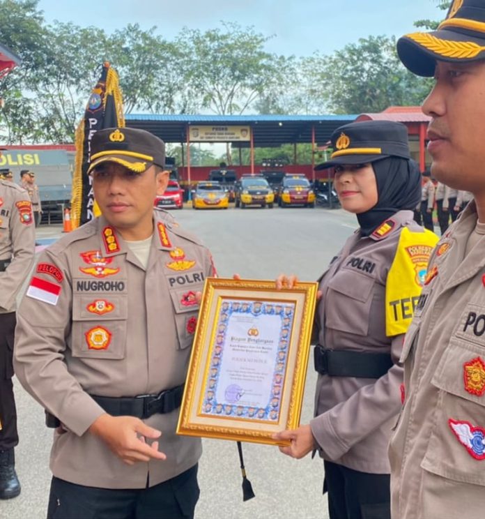 Kapolresta Barelang Kombes Pol Nugroho Tri Nuryanto (kiri)  memberikan penghargaan Polsek Kinerja Terbaik Polsek Jajaran Polresta Barelang Periode Bulan Desember 2022 kepada Kepala Polsek Seibeduk, AKP Betty Novia.  Pemberian penghargaan dilakkan di  Lapangan Apel Mapolresta Barelang, Senin (09/1/2023).  Dalam Pelaksanaan Upacara ini Polsek yang terbaik menerima Bendera Kuning dan Kapolseknya memakai Ban Lengan Kuning yang di berikan langsung kepada Kapolsek Sei Beduk. ( foto : muhammad amin - batamtv.com) 