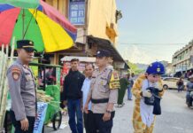 Kanit Samapta Polsek Sekupang Iptu Indra dan Bhabinkamtibmas Sei Harapan Aipda Syefriadi dalam kegiatan pengamanan pasar tumpah di Pasar Sei Harapan Kecamatan Sekupang di Kamis (23/3/2023) (Foto : abyaqsa ramadan - batamtv.com)