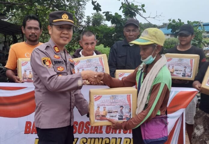 Kapolsek Sei Beduk AKP Benny Syahrizal, S.H., M.H. saat membagikan sembako secara simbolis kepada warga Seibeduk. (Foto : abyaqsa ramadan - batamtv.com)