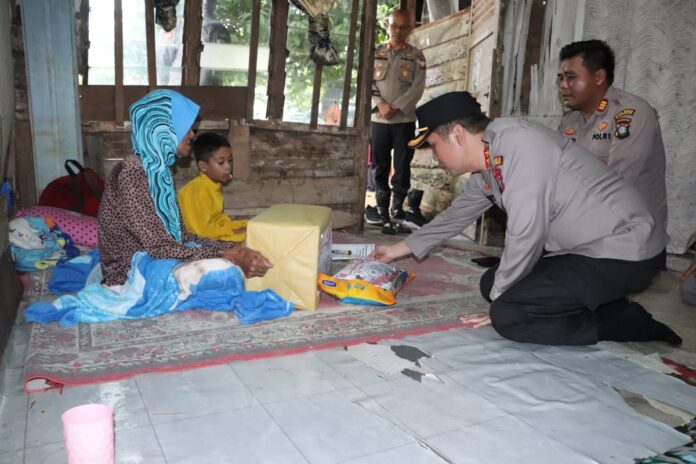 Kapolres Karimun AKBP Ryky W. Muharam S.H., S.I.K (kanan) saat silaturahmi menyambangi warganya  Masita (81 Tahun) di RT 01 RW 02, Kelurahan Darussalam Kecamatan Meral Barat, Kabupaten Karimun. Jumat Berkah. Jum’at (26/05/2023). (Foto : abdi perdana - batamtv.com)