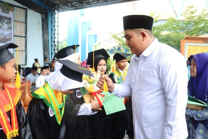 Bupati Bintan Roby Kurniawan (kanan) memindahkan tali toga 10 santri terbaik wisuda 2023.. (Foto : dwi susilo - batamtv.com)