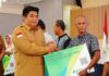 read news – Biaya Kepesertaan BPJS Ketenagakerjaan 3.623 Jiwa Ditanggung Pemkab Bintan Bupati Bintan, Roby Kurniawan (kiri) menyerahkan kartu kepesertaan BPJS Ketenagakerjaan secara simbolis ke perwakilan masyarakat di Aula Kantor Bupati Bintan di Jalan Bandar Seri Bentan, Bintan, Selasa (20/06). (Foto : abdi perdana - batamtv.com)