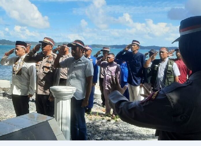 (Foto : dwi susilo - batamtv.com) Kapolsek Bintan Timur AKP Rugianto (depan, kedua dari kiri) dan anggota Polsek Bintan Timur Polres Bintan mengibarkan Bendera Merah Putih di Pulau Sentut Jumat (9/6/2023). (Foto : dwi susilo - batamtv.com)