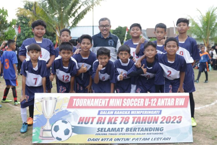 Setdako Batam Jefridin saat bersama salah satu tim U12 pada Turnamen Mini Soccer dan Bola Voli Tingkat Kelurahan Patam Lestari di Lapangan Bola RT 04/10 KSB Mentarau Patam Lestari, yang dibuka resmi Sabtu (08/07/2023). (Foto : muhammad amin - batamtv.com)