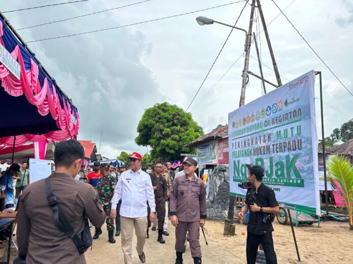 Kepala Kejaksaan Negeri Karimun Firdaus bersama Wakil Bupati Karimun Anwar Hasyim (baju putih topi merah) saat hadir di kegiatan Peningkatan Pelayanan Publik di Desa Jang, Kecamatan Moro, Kamis (6/7/2023). (Foto : abdi perdana - batamtv.com)