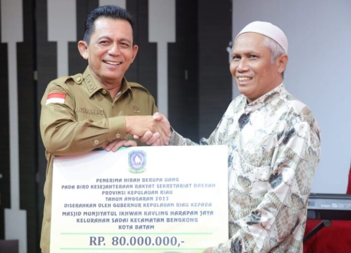 Gubernur Ansar Ahmad saat menyerahkan bantuan insentif kepada salah satu perwakilan RT dan RW di Batam. (Foto : muhammad amin - batamtv.com)
