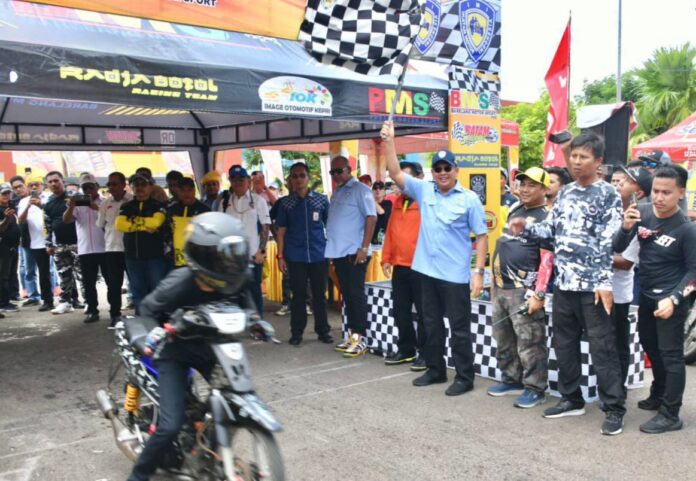 (Foto : muhammad amin - batamtv.com) Ketua IMI Pusat Bamsoet (mengangkat bendera start) usai peresmian Kenduri Otomotif Kepri 2023 Minggu (16/7/2023). (Foto : muhammad amin - batamtv.com)