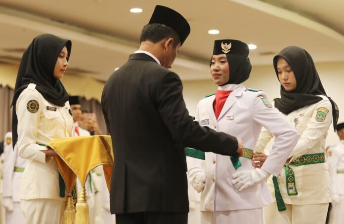 Walikota Batan HM Rudi memasangkan sabuk hijau kepada salh satu perwakilan Paskibraka Kota Batam saat pengukuhan. (Foto : abyaqsa ramadan - batamtv.com)