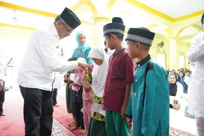 Setdako Batam , Jefridin Hamid saat menyerahkan santunan kepada anak anak di Pulau Buluh yang berhak . (Foto muhammad amin - batamtv.com)