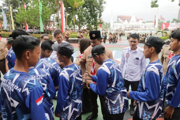 (Foto : abyaqsa ramadan - batamtv.com) Ketua ISSI Kepri HM Rudi, (baju pramuka) saat melepas keberangkatan atlet sepeda yang akan berlaga di Pra PON . (Foto : abyaqsa ramadan - batamtv.com)