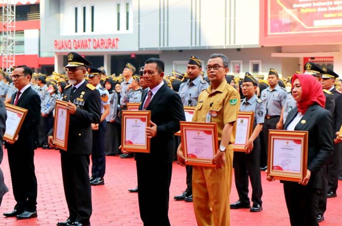 Gubernur Kepri Ansar Ahmad (kiri) menyerhakan SK kepada  703 orang telah memperoleh Penetapan Nomor Induk Pegawai Pemerintah dengan Perjanjian Kerja (NIPPPK) dari Badan Kepegawaian Negara Republik Indonesia,  di Balairung Wan Sri Beni Dompak, Tanjungpinang, Selasa (22/08). (Foto : dwei susilo - batamtv.com)