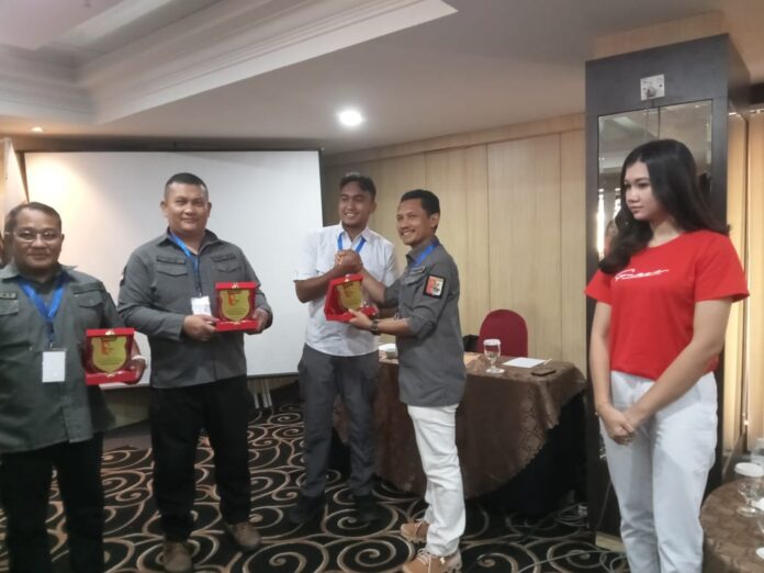 Ketua Panitia Pelaksana (Organizing Commite = OC) Suwando saat menyerahkan plakat kepada para pengurus Prbakin Kabupaten Kota yang hadir dalam Musprov., Sabtu (26/8/2023) (Foto muhammad amin - batamtv,com)