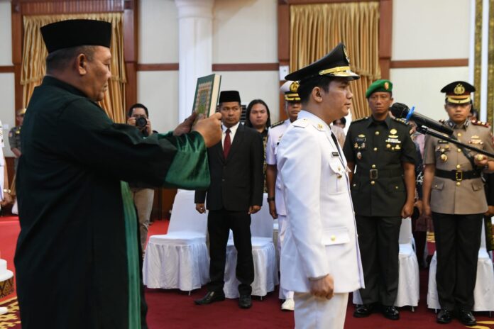 Proses ipelantikan Ahdi Muqsith (PDH putih ) Wakil Bupati Bintan, yang resmi dilantik Gubernur Kepulauan Riau, Ansar Ahmad, Jumat (15/09) di Gedung Daerah. (Foto : abdi perdana - batamtv.com)