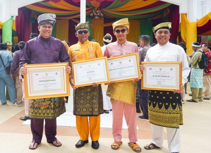 Bupati Bintan Roby Kurniawan (kiri) saat menerima penghargaan penurunan angka prevalensi setunting di HUT Kepri ke 21 di Tanjungpinang, Minggu (24/9/2023). (Foto : dwi susilo - batamtv.com)  