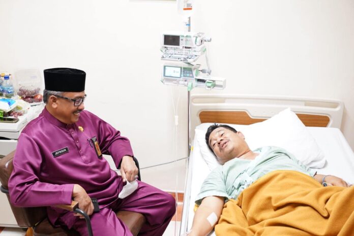 Setdako Batam Jefridin (kiri) saat menjenguk bersama tim Badan Amil Zakat Nasional (Baznas) Kota Batam membesuk Raja Amar di Rumah Sakit Awal Bros (RSAB), Jumat (1/9/2023). (Foto : abyaqsa ramadan - batamtv.com)