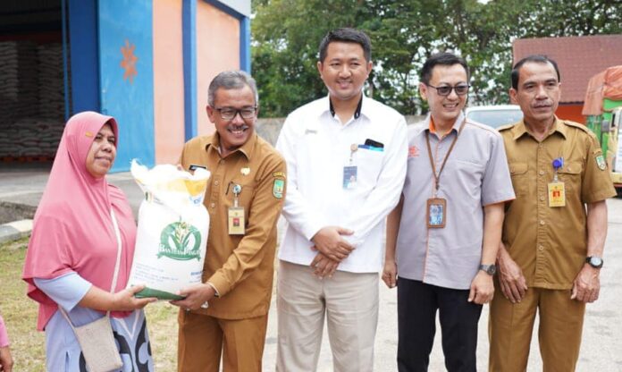 Setdako Batam Jefridin (kedua dari kiri) bersama dengan Kepala Bulog Cabang Batam, Meirizal Sudyadi menyerahkan beras kepada perwakilan masyarakat penerima Beras Cadangan Pangan Pemerintah Tahap ke-2  Senin (11/09/2023).(Foto : muhammad amin - batamtv.com)