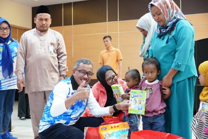 Sekretaris Daerah Kota Batam, Jefridin, (Jongkok berkacamata) memberikan secara simbolis bantuan kepada 81 orang penerima bantuan stunting, dan sebanyak 51 Kartu Keluarga guna mengatasi masalah kemiskinan ekstrem, di Kantor Walikota Batam, Jumat (29/9/2023). (Foto : muhammad amin - batamtv.com)