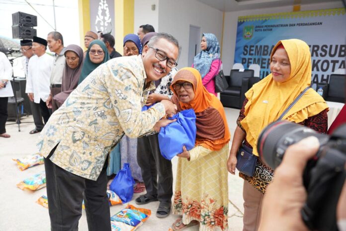Setdako Batam Jefridin (kiri) saat menyerahkan bantuan sembako bersubsidi. (Foto : muhammad amin - batamtv.com )