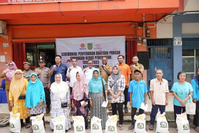 Setdako Batam Jefridin (belakang nomor empat dari kanan) saat Pemerintah Kota (Pemko) Batam juga menggandeng Kantor Pos Cabang Batam mendistribusikan bantuan Pangan Cadangan Beras Pemerintah (CBP) Tahun 2023 Tahap 2 di Kelurahan Sungai Jodoh Kecamatan Batu Ampar, Selasa (7/11/2023) di KCP Pos Batu Ampar.(Foto : muhammad amin - batamtv.com )