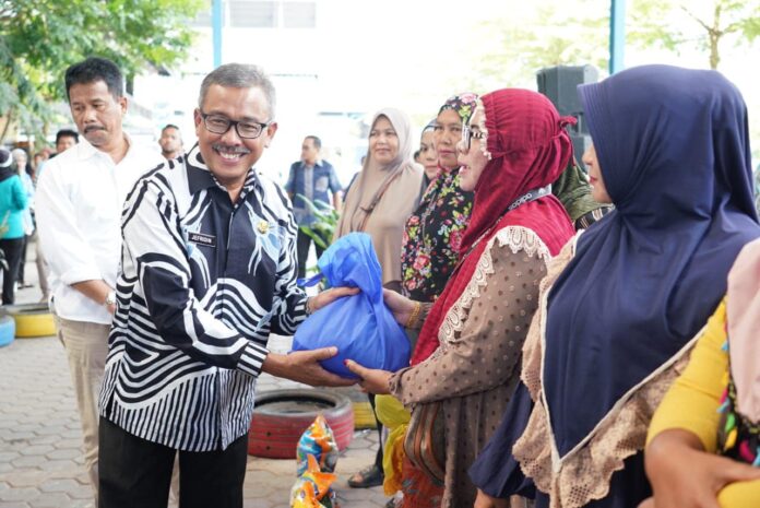 Sekretaris Daerah Kota Batam, Jefridin, M.Pd. (kiri) yang mendampingi Wali Kota Batam, Muhammad Rudi saat penyaluran sembako bersubsidi di Kecamatan Sagulung. (Foto : muhammad amin - batamtv.com)