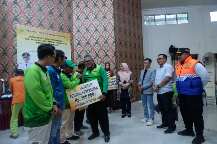 . (Foto : dwi susilo - batamtv.com) Pejabat walikota Tanjungpinang Hasan (ketiga dari kanan) menyerahkan insentif kepada 341 petugas kebersihan yang ada di Kota anjungpinang. Selain menyerahkan insentif , Hasan juga menyerahkan sembako kepada penambang pompong, porter pelabuhan dan bandara RHF sebanyak 402 orang. (Foto : dwi susilo - batamtv.com)