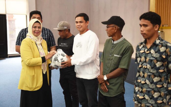 Ketua TP-PKK Provinsi Kepulauan Riau Hj. Dewi Kumalasari Ansar (kiri) saat menghadiri dan menyerahkan secara simbolis bantuan kepada perwakilan masing-masing klub bersama Bupati Bintan Roby Kurniawan.. (Foto : abdi perdana - batamtv.com)