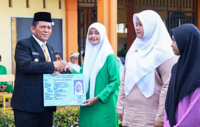 (Foto : dwi susilo - batamntv.com) Gubernur Kepri Ansar Ahmad (jas hitam) menyerahkan secara simbolis KTP-El kepada perwakilan siswa. Acara bertempat di SMA Negeri 7 Tanjungpinang, Jumat (26/1). (Foto : dwi susilo - batamntv.com)