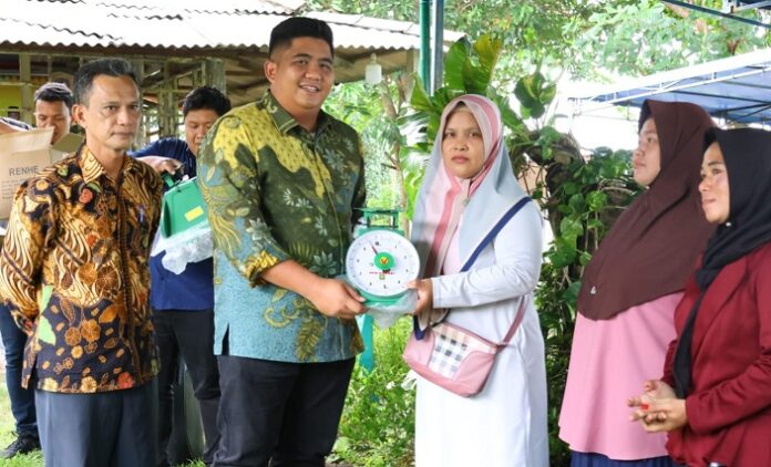 Bupati Bintan Roby Kurniawan (batik kuning hijau) saat menyerahkan timbangan analog . (Foto : abdi perdana - batamtv.com)