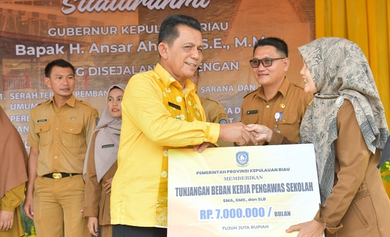 (Foto : abdi perdana - batamtv.com ) Gubernur Kepri Ansar Ahmad (baju kuning) menyerahkan tunjangan Pengawas, Kepala Sekolah, Wakil Kepala Sekolah, Guru ASN, Bendahara BOS, Bendahara SPP, PTK non ASN dan bendahara barang serta bantuan personil. (Foto : abdi perdana - batamtv.com )