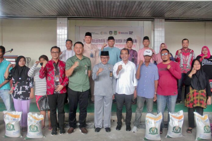 (Setdako Batam Jefridin (depan, kelima dari kanan) saat menyerahkan beras bantuan pemerintah di Kecamatan Batamkota . (Foto : abyaqsa ramadan - batamtv.com)