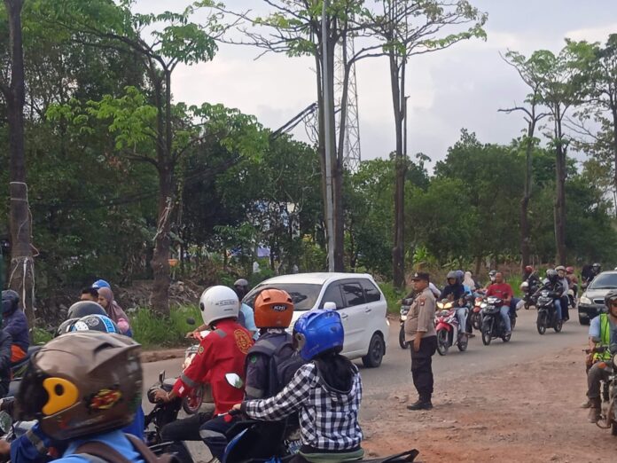 Seorang anggota Polsek seibeudk tengah mengatur lalulintas di pagi hari. (Foto : muhammad amin - batamtv.com)