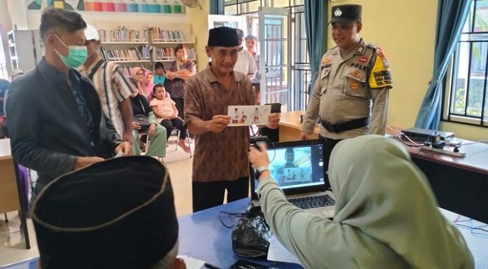 Seorang peserta pencairan BLT difoto dan datanya dimasukkan dalam komputer di Bintan . (Foto : abdi perdana - batamtv.com)