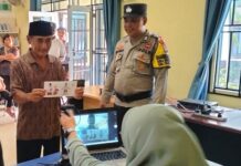 read news Polisi Lakukan Pengawasan Warga Bintan Mulai Pencairan BLT Seorang peserta pencairan BLT difoto dan datanya dimasukkan dalam komputer di Bintan . (Foto : abdi perdana - batamtv.com)