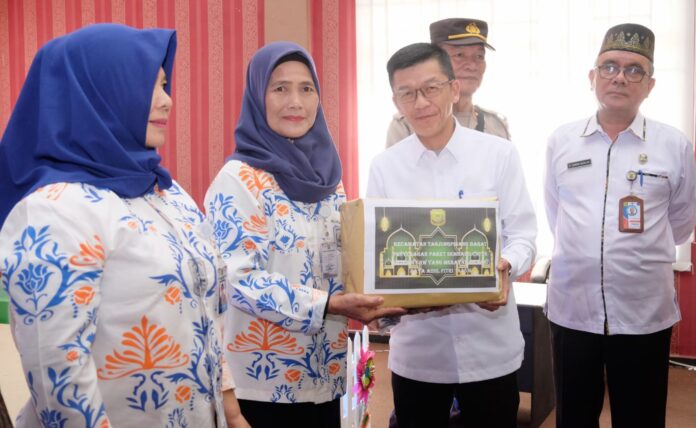 Penjabat (P.j) Wali Kota Tanjungpinang, Hasan,S.Sos secara simbolis membagikan bantuan paket sembako di Kantor Kecamatan Tanjungpinang Barat didampingi oleh Asisten I Thamrin Dahlan. (Foto : dwi susilo - batamtv.com)